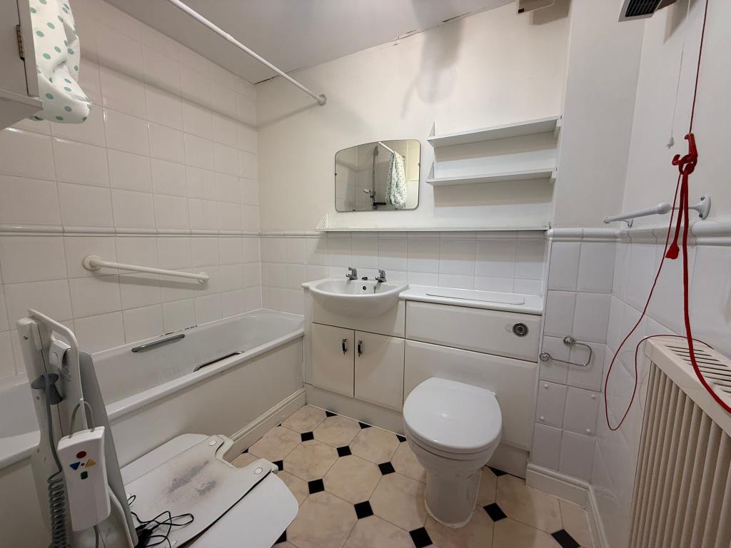 Lot: 50 - TWO-BEDROOM RETIREMENT FLAT IN NEED OF IMPROVEMENT - Tiled accessible 3 suite bathroom with chair lift